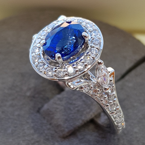 Oval blue halo sapphire and diamond platinum ring, floral design on ring